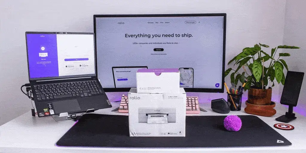 Rollo wireless printer box in front of laptop and desktop monitor.